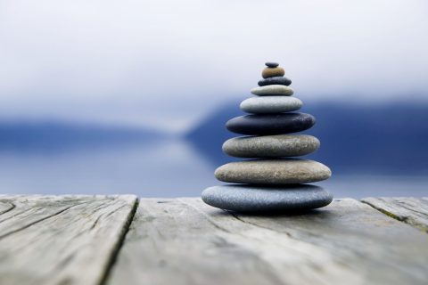 Zen balancing pebbles next to a misty lake. Image by rawpixel.com on Freepik